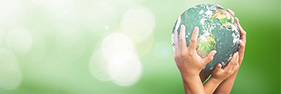 Image of hands holding the World with a green background